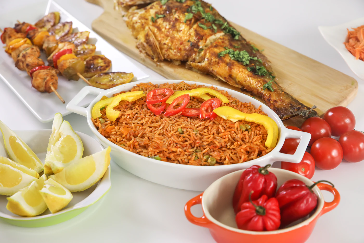 Jollof rice served with grilled fish and skewers
